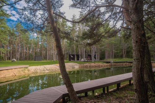 a wooden bench next to a pond in a park at Tiny holiday complex in Kalana in Kalana