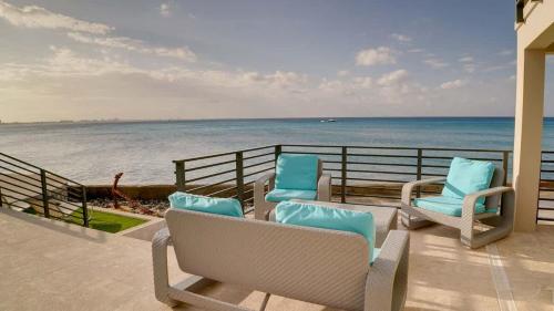 a balcony with chairs and a view of the ocean at Seven Mile View Condo #4 in West Bay