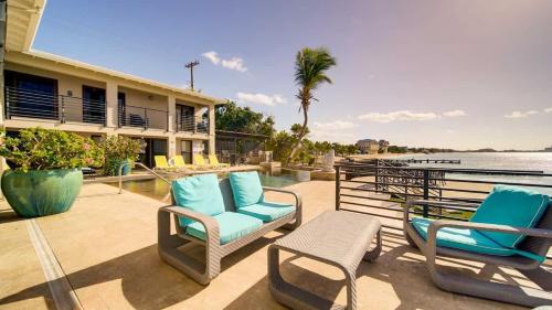 a patio with chairs and a pool and a house at Seven Mile View Condo #4 in West Bay