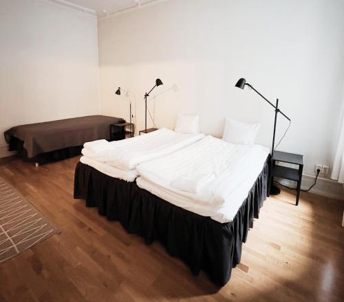 a large white bed in a room with two lamps at Hotel Lemonade in Gothenburg