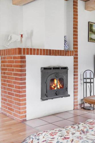 a brick fireplace with a fire in it at 2605-Romo-A-Hansensvej-3 in Vesterhede