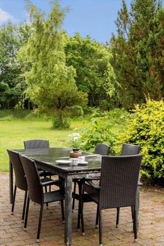 a black table and chairs with a table and trees at 2605-Romo-A-Hansensvej-3 in Vesterhede
