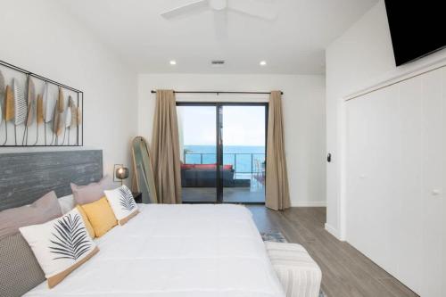 a white bedroom with a large bed and a couch at Allure #22 3BR Waterfront in Red Bay Estate