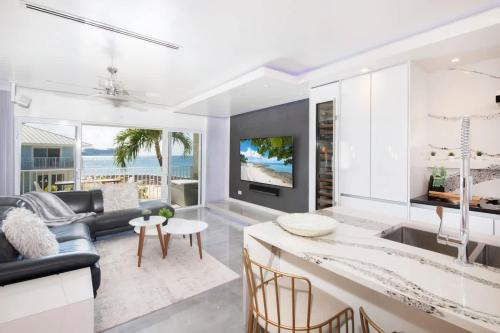 a kitchen and living room with a couch and a tv at Grape Tree Condo #10 in George Town