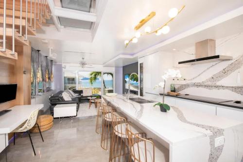 a kitchen and living room with a bar with stools at Grape Tree Condo #10 in George Town
