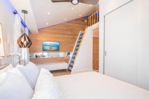 a bedroom with a white bed and a staircase at Grape Tree Condo #10 in George Town