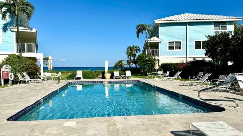 a swimming pool in front of a house at Grape Tree Condo #10 in George Town