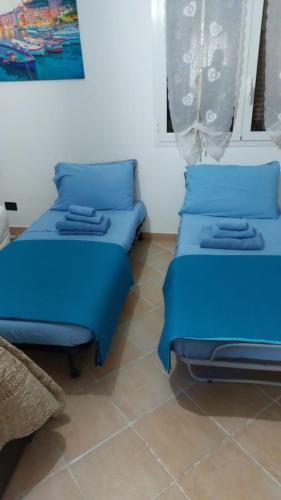 two beds in a room with blue cushions at CASA RINA in Ventimiglia