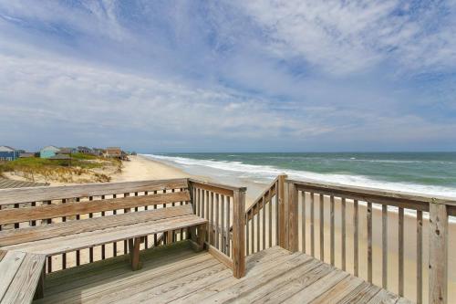 a wooden deck with a bench looking at the ocean at 7144 - Dolphin Lookout ( formerly Sabah Vacations) in Wanchese