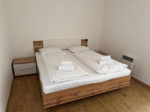 a bedroom with a bed with white sheets and pillows at L&B Lake view modern apartment in Lipno nad Vltavou