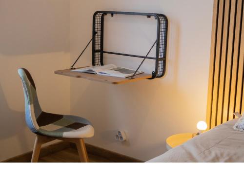 a chair and a mirror on a wall next to a bed at Truffiers Charentais Résidence in Val-de-Bonnieure