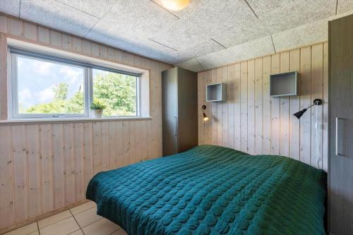 a bedroom with a green bed in a room with a window at 2002-Romo-Juvrevej-51b in Toftum