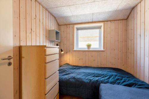 a small bedroom with a bed and a window at 2002-Romo-Juvrevej-51b in Toftum