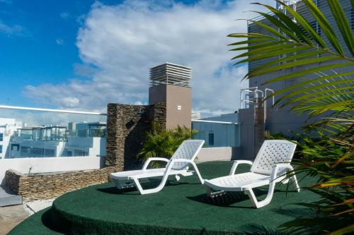 two chairs sitting on top of a roof at Reserva Del Mar Apartamentos in Gaira
