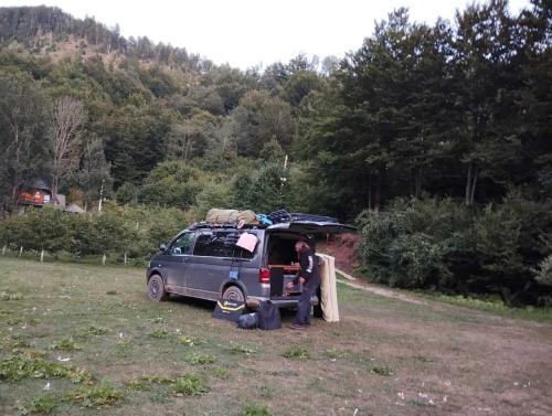 a man standing next to a van with its door open at Holiday bungalows Pajkovir in Kolašin