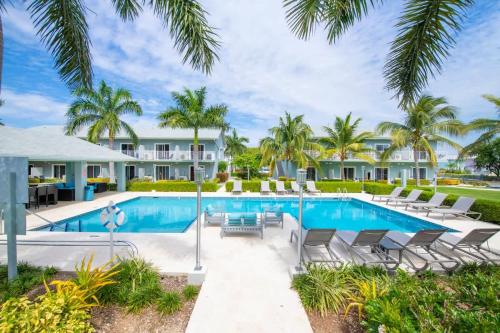 a villa with a swimming pool and palm trees at Summertime Suites #50 in West Bay