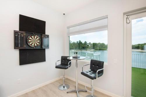 a room with a table and two chairs and a dartboard on the wall at Summertime Suites #50 in West Bay