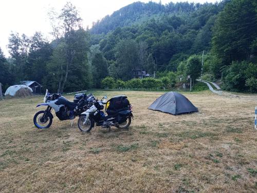 two motorcycles parked in a field next to a tent at Holiday bungalows Pajkovir in Kolašin