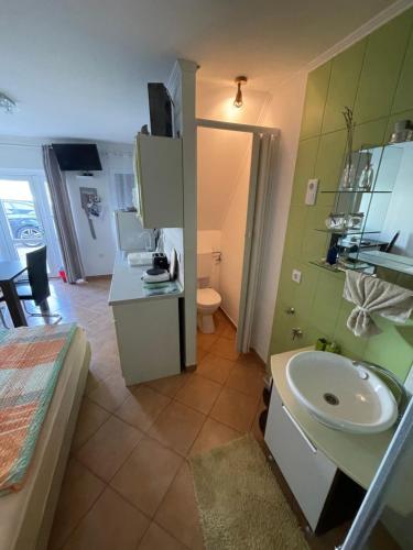 a bathroom with a sink and a toilet in a room at Pol-Lak in Szőlősgyörök