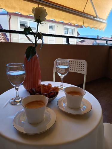 a table with two cups of coffee and pastries on it at Venus Deluxe Apartment in Strumica