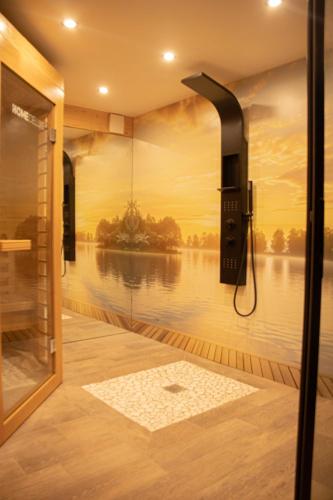 a bathroom with a shower with a view of the water at La Villa Aliénor - Spa et Cinéroom in Montigny-Lencoup