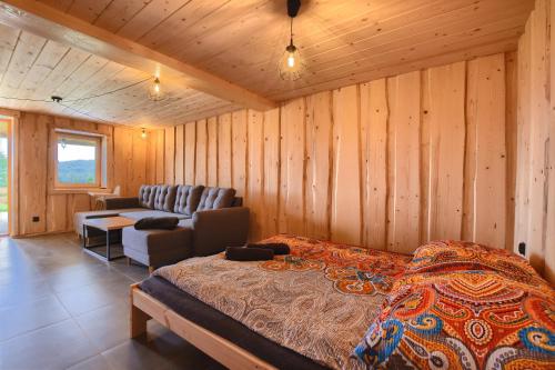 a bedroom with a bed and a couch and a chair at Wioska Koniaków in Koniaków