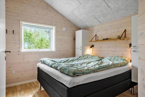 een bed in een kamer met een raam bij 0308-Romo-Vagtelvej-4 in Mølby