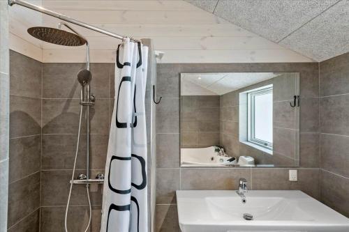 een badkamer met een douchegordijn en een wastafel bij 0308-Romo-Vagtelvej-4 in Mølby