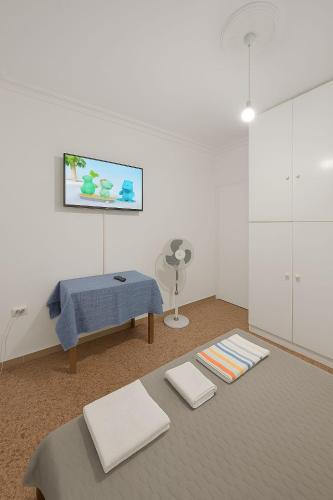 a white room with a bed and a fan at Your refuge overlooking port 6A in Mesochórion