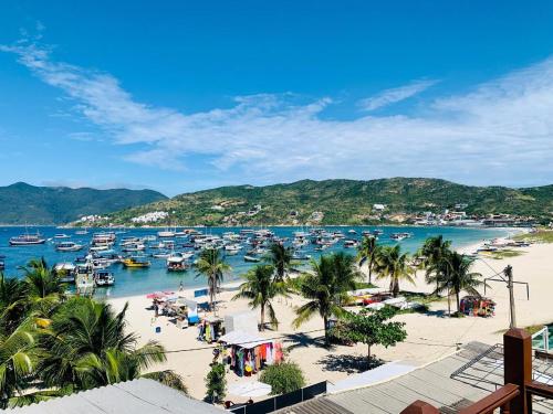 a beach with boats in the water and palm trees at pe na areia in Arraial do Cabo