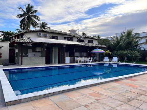 ein Swimmingpool vor einem Haus in der Unterkunft Condomínio Ouro – Piscina e Praia a Poucos Passos in Porto Seguro