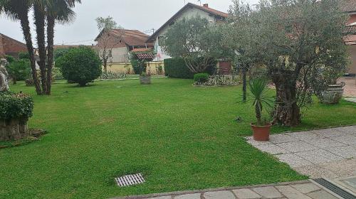 a yard with a green lawn with trees and a house at A casa di 'Nuccia' in Foglizzo