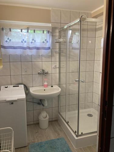 a bathroom with a shower and a sink at Rusałka Domek nad Jeziorem in Rudno