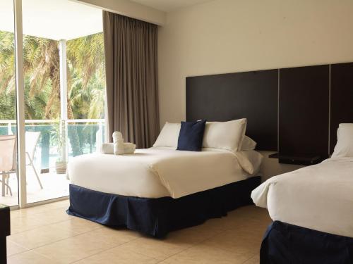 a bedroom with two beds and a large window at Beach Apartment Nikki Steps From The Sea in El Chirú