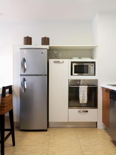 a kitchen with a refrigerator and a microwave at Beach Apartment Nikki Steps From The Sea in El Chirú