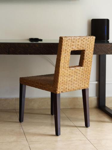 a wicker chair sitting in front of a desk at Beach Apartment Nikki Steps From The Sea in El Chirú