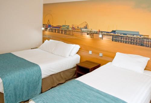 two beds in a hotel room with a view at Best Western Carlton Hotel in Blackpool