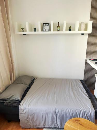 ein Bett in einem Zimmer mit einer weißen Wand in der Unterkunft Cozy Apartment next to the train station and near the city center in Bratislava