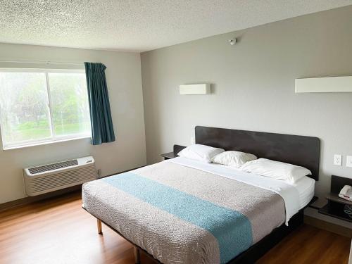 a bedroom with a large bed and a window at Studio 6 Indianapolis, IN - Southport in Indianapolis