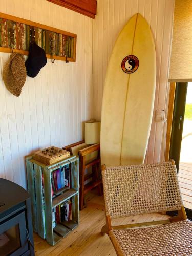 a room with a surfboard sitting next to a chair at Redondo Beach frente al océano in Maldonado