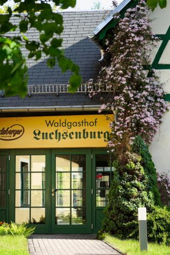 a building with a green door and a sign at Forsthaus Luchsenburg in Ohorn