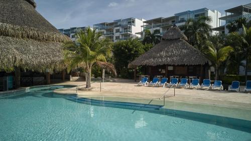 a swimming pool with chairs and a resort at Beach Apartment Nikki Steps From The Sea in El Chirú
