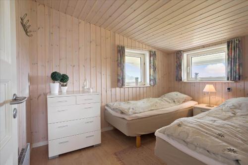 Un dormitorio con dos camas y una cómoda y dos ventanas. en 0056-Romo-Lakolk-50, en Lakolk