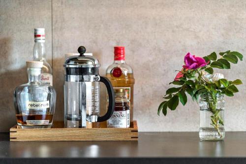 a wooden shelf with bottles of alcohol and a vase with a flower at 530-Lemvig-Lokkevej-59-D in Lemvig