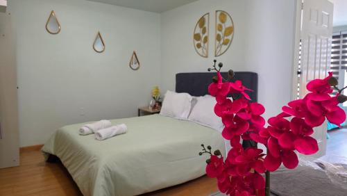 a bedroom with a bed with red flowers on it at Departamento céntrico, amplio y nuevo cerca del Aeropuerto y GNP-Foro sol in Mexico City