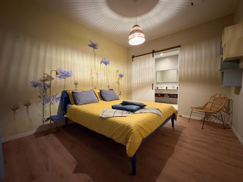 a bedroom with a bed with yellow sheets and blue pillows at B&B De Korenbloem in Noordbroek