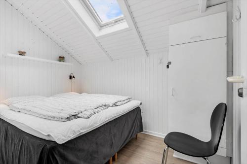 a bedroom with a bed and a chair in it at 0415-Romo-Vestergade-3-Ap-15 in Havneby