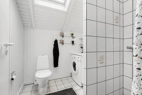 a white bathroom with a toilet and a sink at 0415-Romo-Vestergade-3-Ap-15 in Havneby