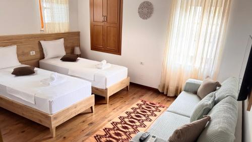 a living room with two beds and a couch at Mezini Guest House in Gjirokastër