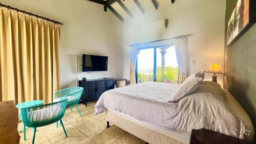 a bedroom with a bed and two chairs and a window at Ruta Verde BB in Tambor